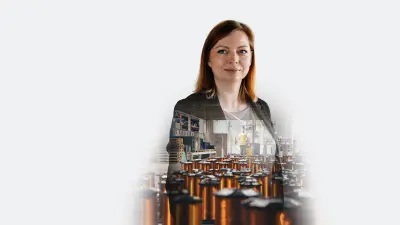 Juliane Lüder, a Bosch Data Scientist, stands confidently in a modern office environment, demonstrating AI concepts on a screen.