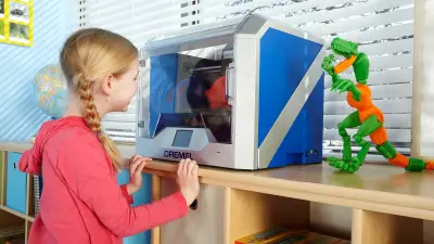 Eine Schülerin steht vor einem 3D-Drucker von Dremel und schaut beim Druckvorgang zu. Daneben steht ein ausgedrucktes Modell eines Dinosauriers.