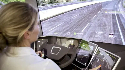 At the wheel of the Bosch Vision X concept study. The display shows a road and many projections.