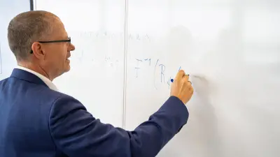 Uwe Iben writing on a whiteboard.
