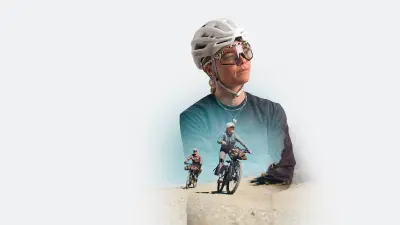 Two people riding e-bikes on an unpaved road in an open landscape.