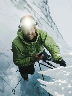 Bernard Witz is smiling while hanging from a rope on an icefall. The holes have been drilled with a cordless Bosch Biturbo rotary hammer.