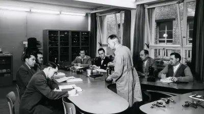 Instructor demonstrating machine part to class.