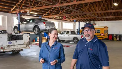 Two people talking in a Bosch Auto Service garage.