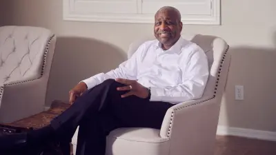 Homeowner Antoine Coffer is sitting in an armchair in his living room.