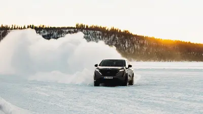 Ein Auto fährt durch den Schnee.
