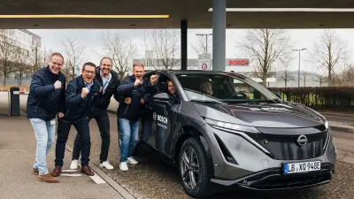 Mehrere Personen und ein Testauto stehen vor dem Firmengelände in Abstatt
