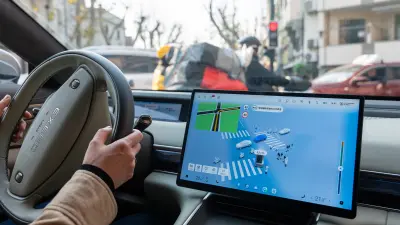 Eine Fahrerin nutzt ein Assistenzsystem von Bosch im Stadtverkehr von Shanghai, das die Fahrzeugumgebung auf dem zentralen Display visualisiert.