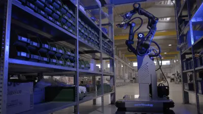 Ein mobiler Roboter von Bosch Rexroth mit Greifarm sucht in einem blau be-leuchteten Lagerregal nach Bauteilen.