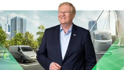 Stefan Hartung stands in front of various vehicles with a variety of drive technologies.