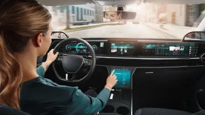 Frau schaut in einem Auto auf ein Display