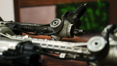 Close-up of two steering systems lying side by side. One shows signs of wear, the other looks like new.