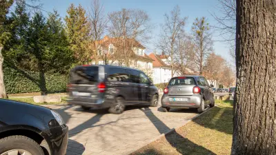 Das Bild zeigt ein einparkendes Fahrzeug in einem Wohngebiet.