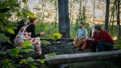 Adam Detre is sitting around a campfire in the woods with his friends, talking.
