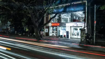 An exterior shot at night shows a brightly lit Bosch store with "BOSCH Invented for life" signage, with long light trails from passing cars on the street in the foreground.