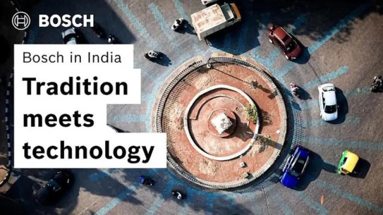 Street traffic with auto rickshaws and motorcycles in an urban setting.