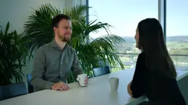 Patrick talks to a colleague sitting opposite him.