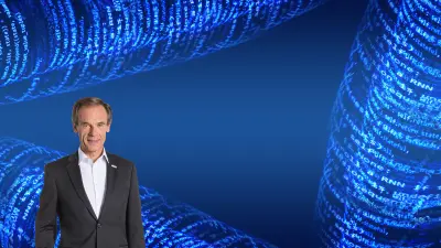Volkmar Denner vor einem blauen Hintergrund mit Software-Code