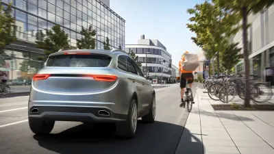 Ein Auto überholt in einer Stadt ein Fahrrad.