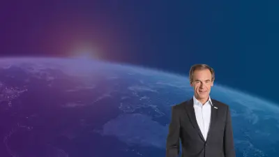 Dr. Volkmar Denner in the foreground and the earth in the background.