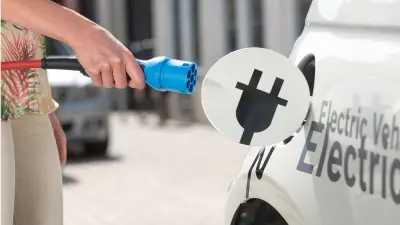 Frau betankt ihr Auto mit Strom