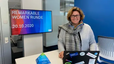 Stefanie Jekal, global Diversity-Managerin, standing in front of a desktop showing a presentation with the topic “Remarkable women”