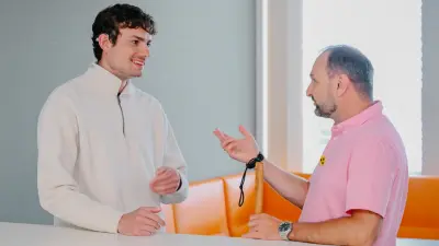 Jonas unterhält sich mit einer Person, die das Verkehrsschutzzeichen für Personen mit Beeinträchtigung trägt.