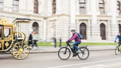 Eine Frau fährt mit ihrem Fahrrad durch Wien.