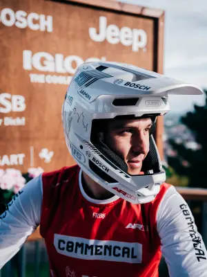 Portrait of a mountain biker wearing a white helmet and red Commencal jersey.
