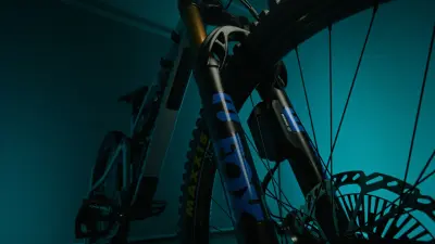 Close-up of a mountain bike front fork, wheel, brake disc and Bosch component.