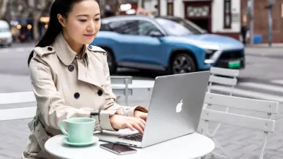 Automobil-Managerin Cissy Ye sitzt in Shanghai in einem Straßencafé und arbeitet am Computer. Im Hintergrund fährt der elektronische SUV NIO ES8.