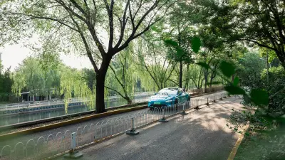 A car parked in a lush green park setting, surrounded by trees and a pond. 