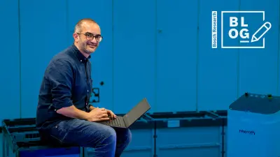 Bosch Research expert Lugi Palmieri is sitting with his laptop on his knees in the robotics laboratory at the Bosch Research site in Renningen, Germany