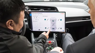 Zwei Mitarbeitende sitzen in einem Auto und führen Messungen durch.
