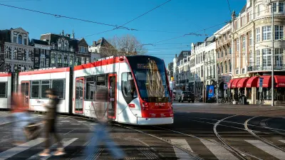 Eine Straßenbahn fährt an einer Kreuzung in Den Haag um die Kurve.