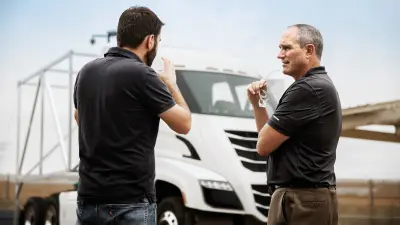 Mark Russell (right), the president of Nikola Motor Company, gets the latest updates on the test drives from Bosch engineer Christian Appel.