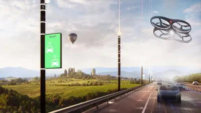 Eine Smart Road, auf der Autos fahren. Darüber schwebt eine Drohne, im Hintergrund fliegt ein Heißluftballon.