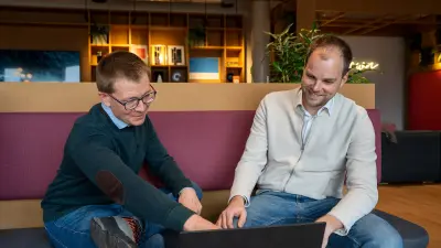 Two men working together on a laptop