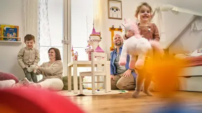 Melanie und David Wingerter sitzen bzw. hocken im Kinderzimmer und spielen mit ihren Kindern Karl und Elisabeth.