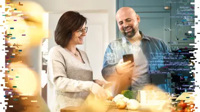 Melanie und David Wingerter schauen zusammen auf ein Smartphone und lachen dabei herzhaft.