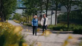 Antje and Max are walking along a path outside the site and chatting