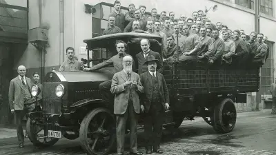 A group of workers in the open back of a truck, Robert Bosch in front of it
