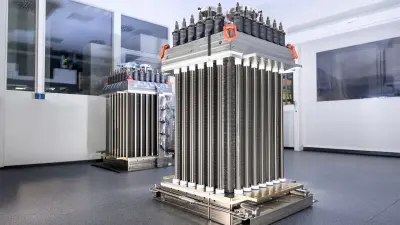 Two large, industrial battery stacks in a clean, white room with black flooring.