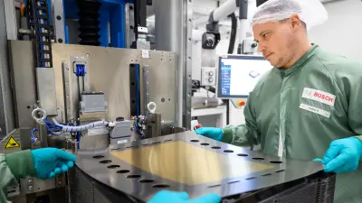 Workers handle a large component.