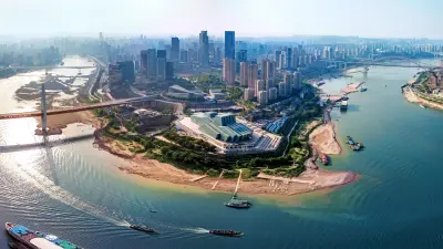 View of a megacity. Pictured are skyscrapers in a densely developed urban setting, intersected by a wide river.