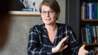 Malene Freudendal-Pedersen sitzt an einem Tisch und diskutiert mit ihrem Gesprächspartner.