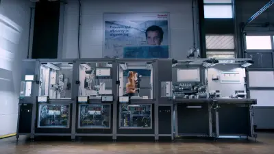 The illuminated production line, consisting of three glass boxes and two desks with many robots and devices.