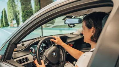 Person driving a test vehicle in front of a simulated road environment