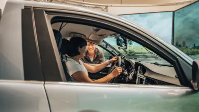 Person at the wheel of an instrumented test vehicle while another person stands outside