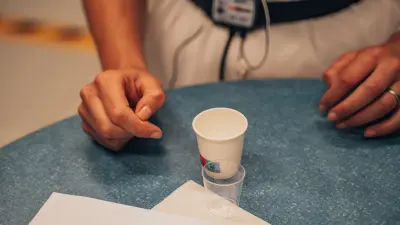 Person using a handheld breath test device while another person observes